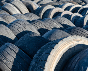 Used tire dump,  rubber waste and recycling challenges. Tires of various sizes and brands are piled up in irregular stacks, disturbing landscape of industrial waste