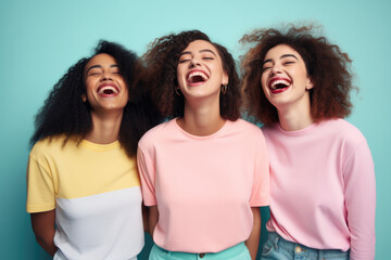 Three women wearing different colored shirts are laughing together