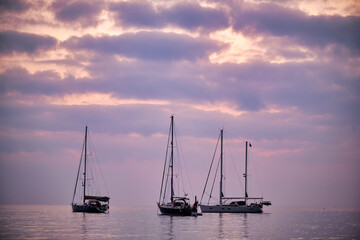 A group of sailboats rests during sunrise on the coast of Peñiscola.