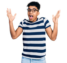 Young african american man wearing casual clothes and glasses celebrating crazy and amazed for...