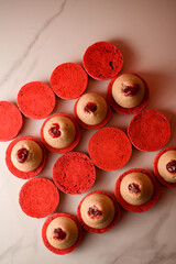 Top view photo of red macaroons with beige and red cream