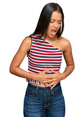 Fototapeta premium Beautiful hispanic woman wearing casual clothes with hand on stomach because nausea, painful disease feeling unwell. ache concept.