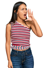 Beautiful hispanic woman wearing casual clothes shouting and screaming loud to side with hand on mouth. communication concept.