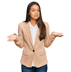 Beautiful hispanic woman wearing business jacket clueless and confused expression with arms and...