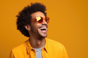 A man wearing sunglasses and a yellow shirt is laughing