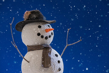 Close-up of snowman wearing a hat while snowing