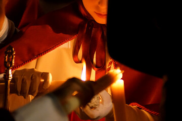 A girl collecting wax from a Nazarene candle