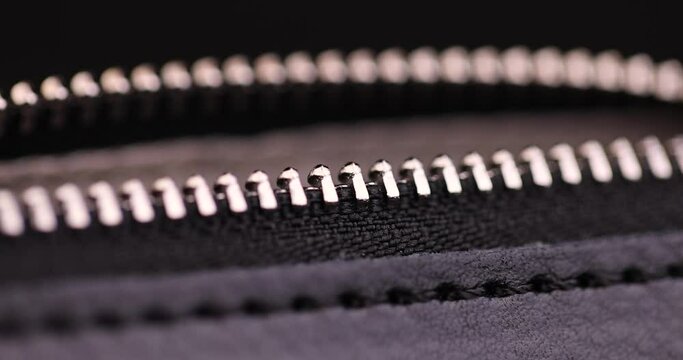 metal zipper on a black leather product, zipper on a black women's handbag close-up