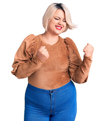 Young blonde plus size woman wearing casual sweater excited for success with arms raised and eyes closed celebrating victory smiling. winner concept.