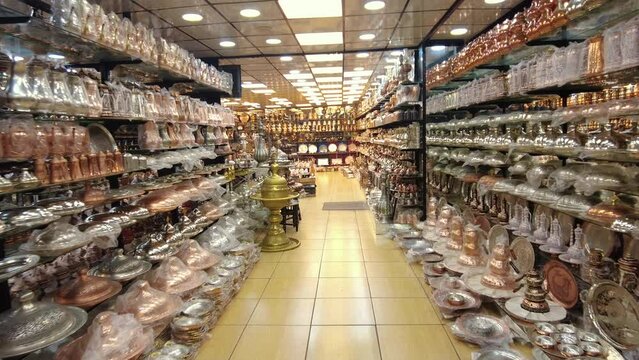It is a shop selling traditional copper kitchenware. Yellow, brown, gray and white shades of copper are seen.