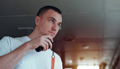 Deck Officer On The Bridge During Navigational Watch At Sea. Offshore Technician. Seafarer. Seaman. Navigator. A Man In The Wheelhouse Holding A Radio Station. Chief Officer On The Merchant Ship. © I am from Mykolayiv