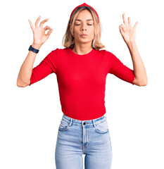 Beautiful caucasian woman wearing casual clothes and red diadem relax and smiling with eyes closed doing meditation gesture with fingers. yoga concept.