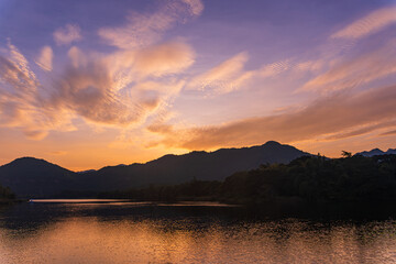 Beautiful lakeside view from a small lake in Kanchanaburi Thailand, with water reflect sunset sky