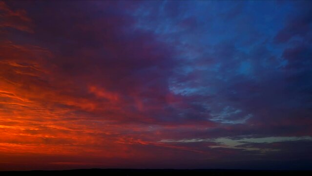 Panning across amazing red dawn sky, aerial view.
