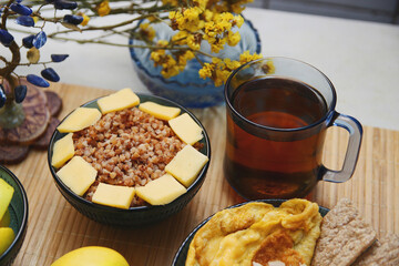 Homemade Ukrainian dinner - buckwheat with cheese, apples, tea. In blue and yellow colors.