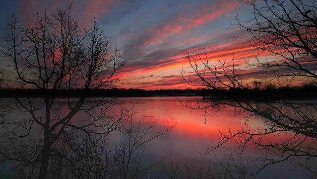 Amazing December dawn sky reflected in a thin layer of ice as the river freezes over.
