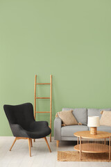 Armchair with couch, ladder and coffee table near green wall