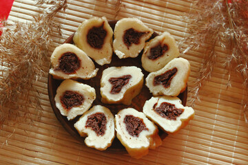 Homemade baked goods - handmade grilled cookies, chopped dumplings, nuts, clay cup of tea on a red background.