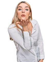 Young caucasian woman wearing casual clothes looking at the camera blowing a kiss with hand on air being lovely and sexy. love expression.