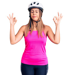 Young beautiful woman wearing bike helmet relax and smiling with eyes closed doing meditation gesture with fingers. yoga concept.