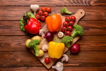 Board with different fresh vegetables on wooden background