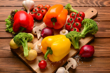 Board with different fresh vegetables on wooden background