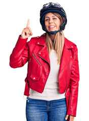 Young beautiful woman wearing motorcycle helmet pointing finger up with successful idea. exited and happy. number one.