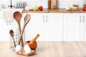 Cooking utensils and eggs on table in kitchen