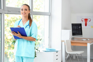 Female medical student writing in clipboard at university