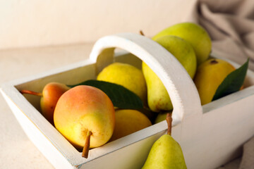 Basket with ripe pears on white background