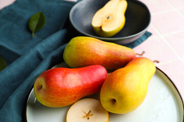 Plate with ripe pears on table