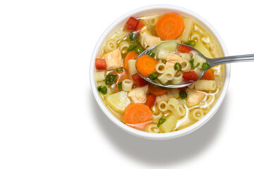 chicken soup with vegetables in a white bowl with a spoon