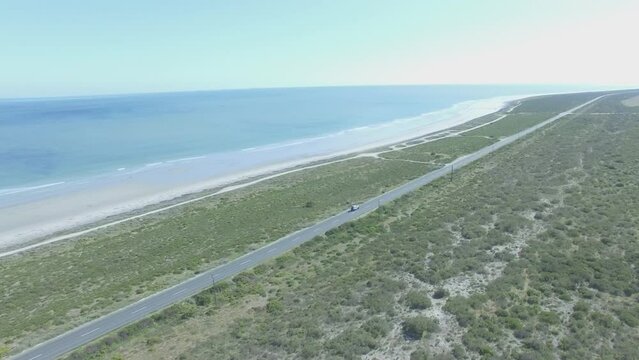Road trip, sea and car on street with travel, adventure and countryside landscape by ocean. Highway, aerial and top view with drone and drive with transportation in California outdoor with water
