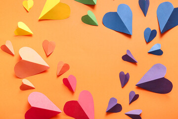 Frame made of colorful paper hearts on orange background. LGBT concept