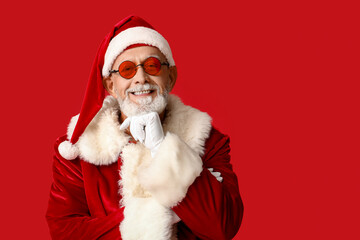 Santa Claus in sunglasses on red background