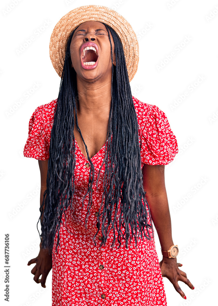 Wall mural Young african american woman wearing summer hat angry and mad screaming frustrated and furious, shouting with anger. rage and aggressive concept.