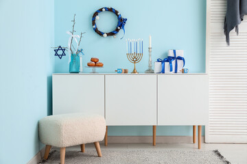 Interior of festive living room with pouf, white cabinet and decorations for Hanukkah celebration