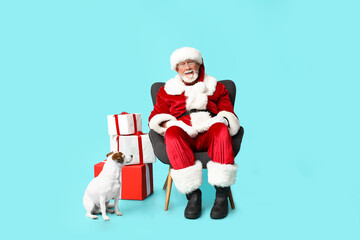 Santa Claus with cute Jack Russell Terrier dog and Christmas gift boxes on blue background