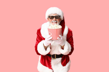 Santa Claus in 3D glasses with bucket of tasty popcorn on pink background