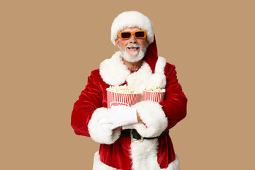 Santa Claus in 3D glasses with buckets of tasty popcorn on brown background