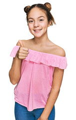 Fototapeta premium Beautiful brunette little girl wearing summer pink shirt smiling happy and positive, thumb up doing excellent and approval sign