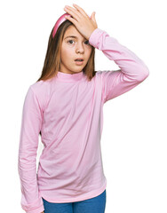 Beautiful brunette little girl wearing casual turtleneck sweater surprised with hand on head for mistake, remember error. forgot, bad memory concept.