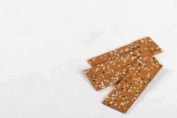 Vegan Buckwheat bread with sesame seeds and quinoa, in the form of thin strips. White background. Copy space
