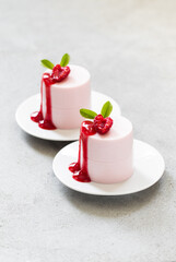 Modern dessert. Raspberry cream pudding. Panna Cotta. With sauce. On a plate. Close up