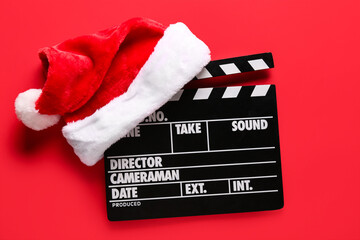 Movie clapper with Santa hat on red background