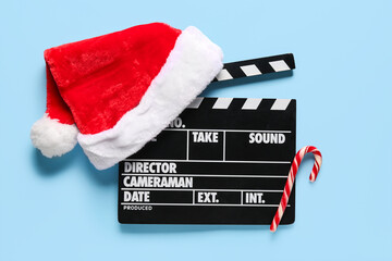 Movie clapper with Santa hat and candy cane on blue background