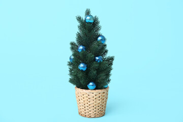Beautiful Christmas tree in pot on blue background