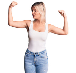 Fototapeta premium Young beautiful blonde woman wearing casual sleeveless t-shirt showing arms muscles smiling proud. fitness concept.