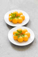 Modern dessert. Carrot cream pudding in the shape of truffles, with parsley. On a plate. Top view