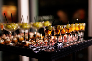 Variety of appetizers and snacks in small glasses at the event